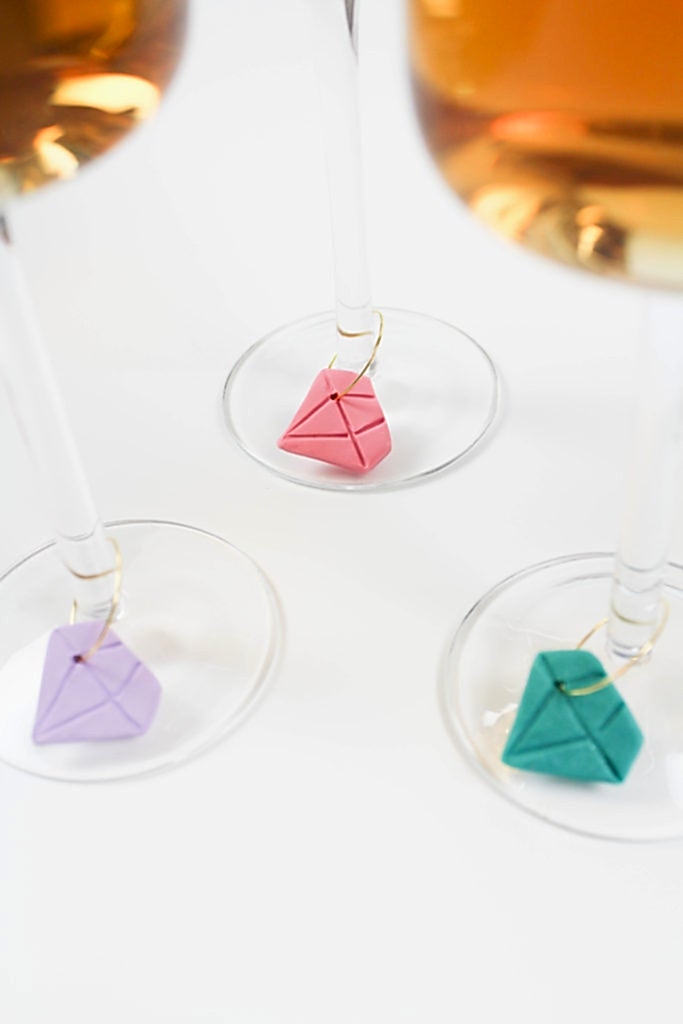 Three wine glasses with multicolored gem-shaped wine charms for bridal shower favors