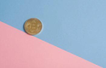 A coin placed on a backdrop of blue and pink
