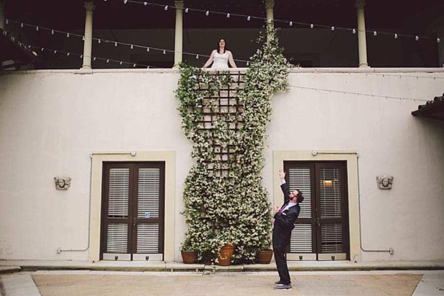 A wedding couple acts out the balcony scene from Romeo & Juliet