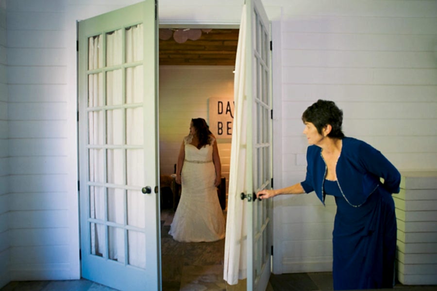 A mother of the bride opening a door and peaking in on her daughter about to wed