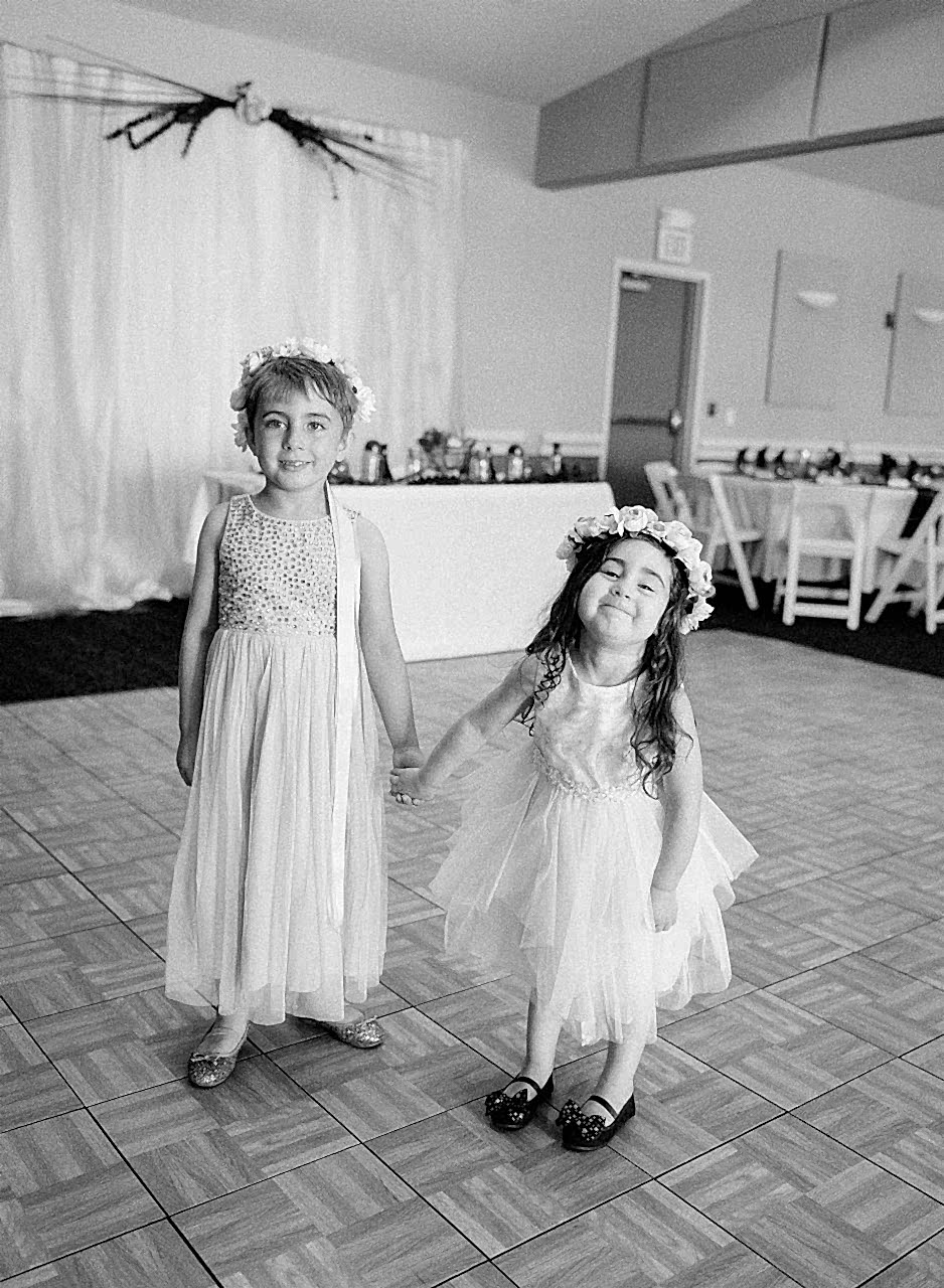 A flower boy and a flower girl holding hands