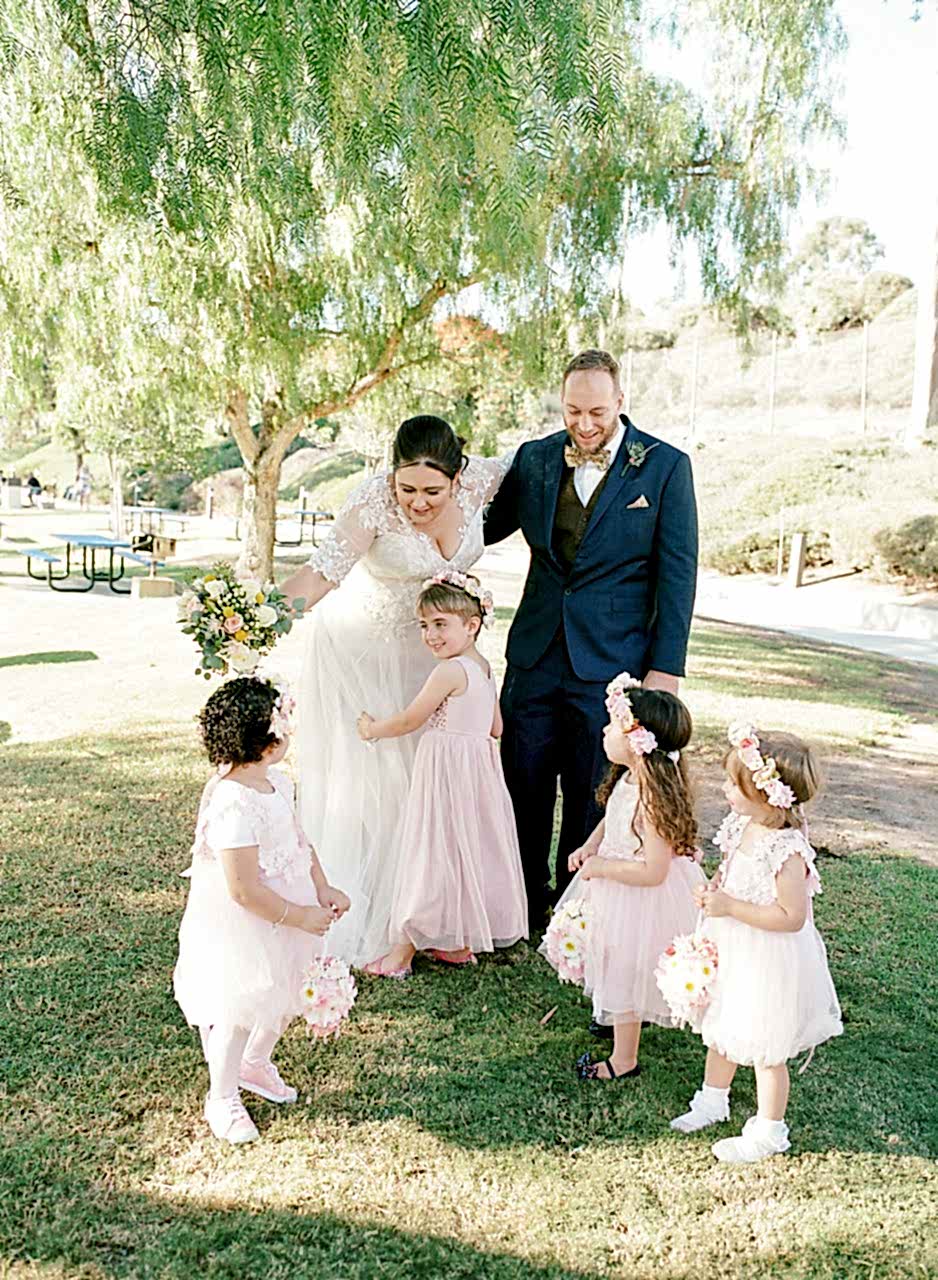 A wedding couple standing with their flower kids