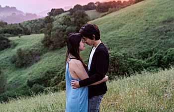 A couple hugs on a mountainside while thinking about engagement anxiety