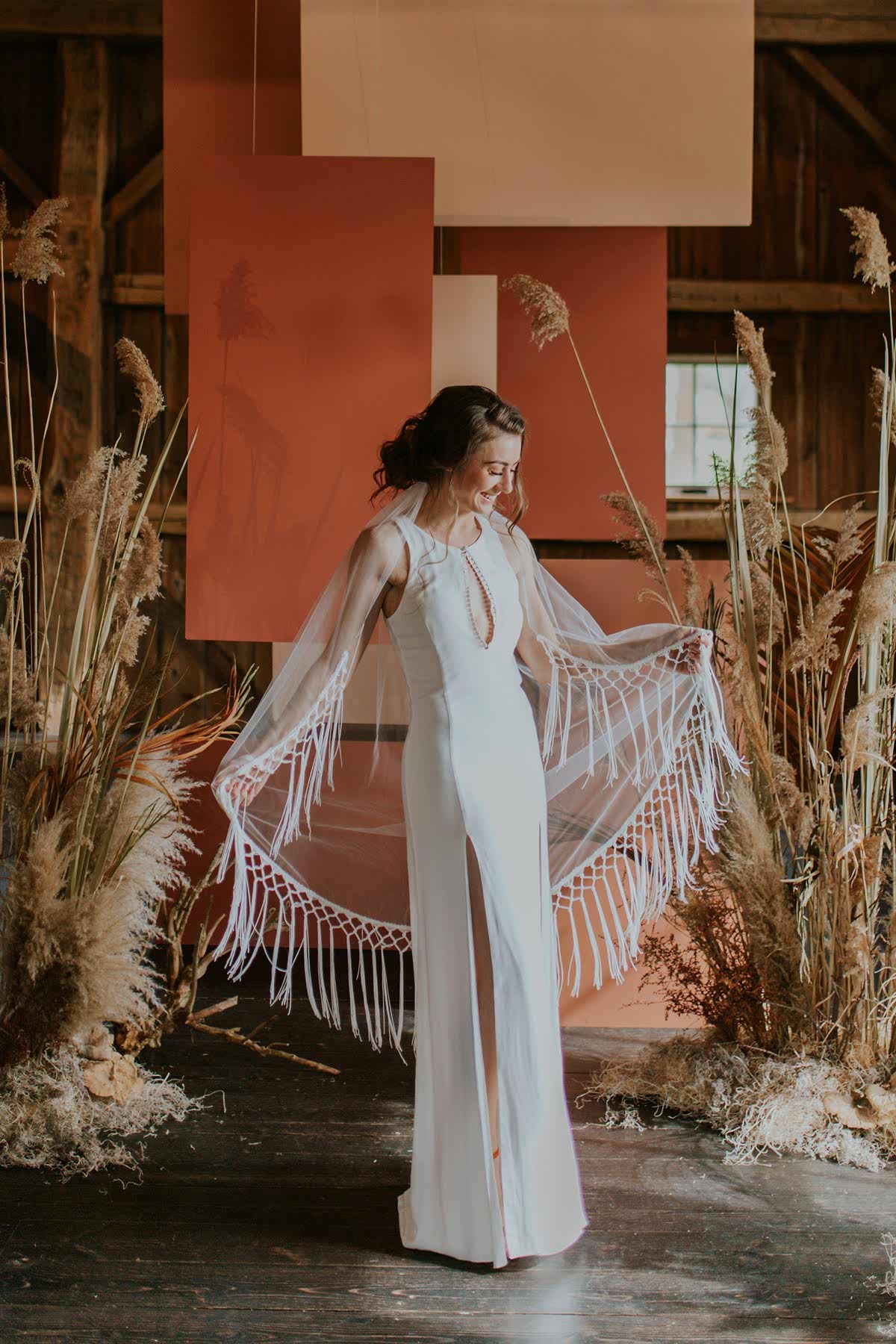 A woman shows off her wedding dress and smiles