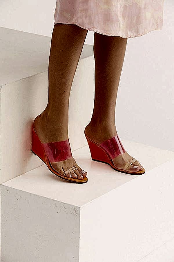 A pair of orange colored wedge shoes