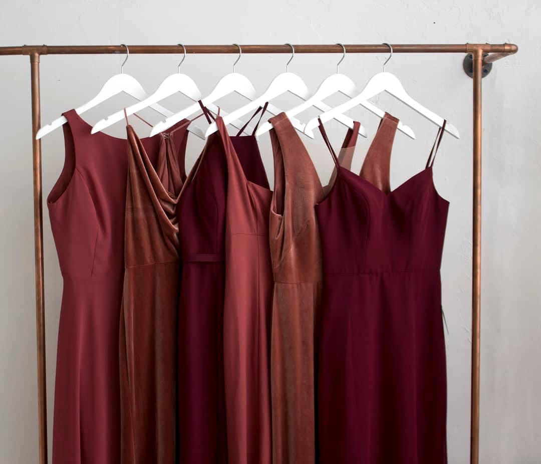 A rack full of dresses in various shades or red