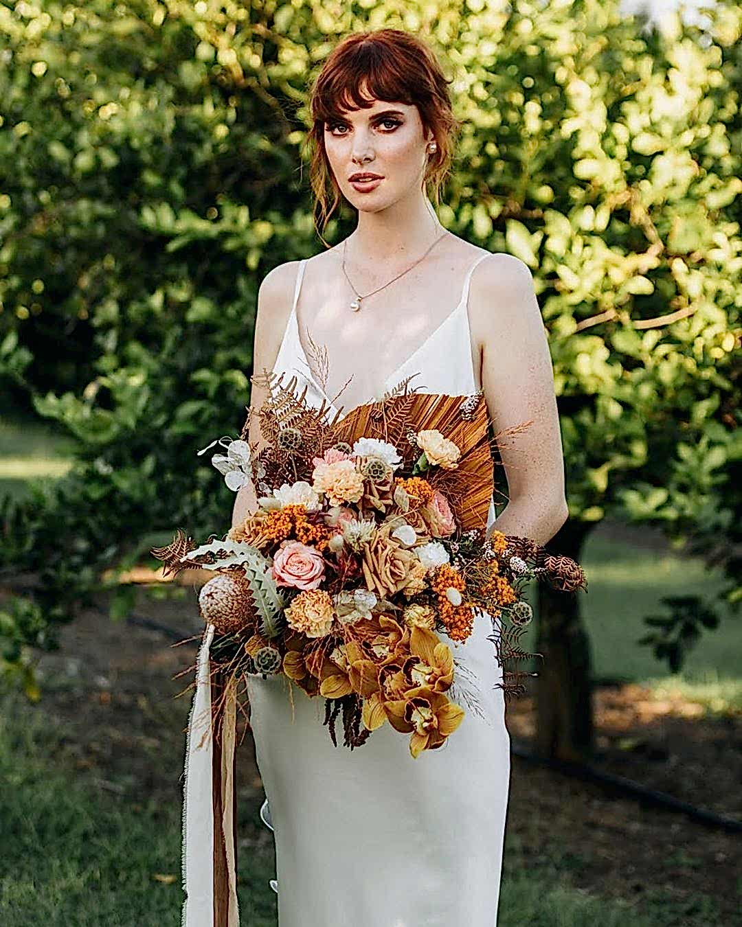 A model holds a bouquet with fall wedding colors in mind for the flower selection