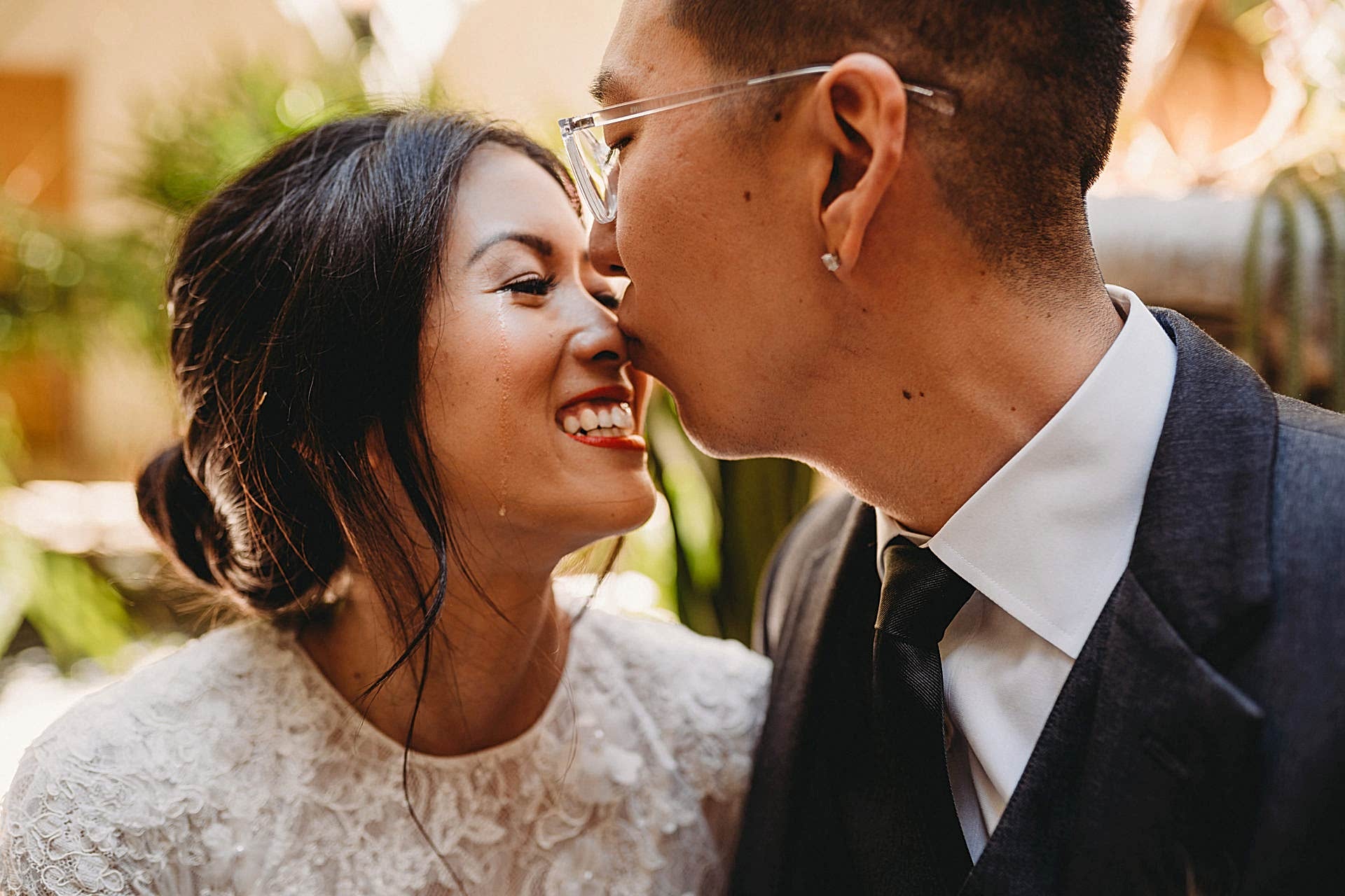 A person kisses his partner's nose.