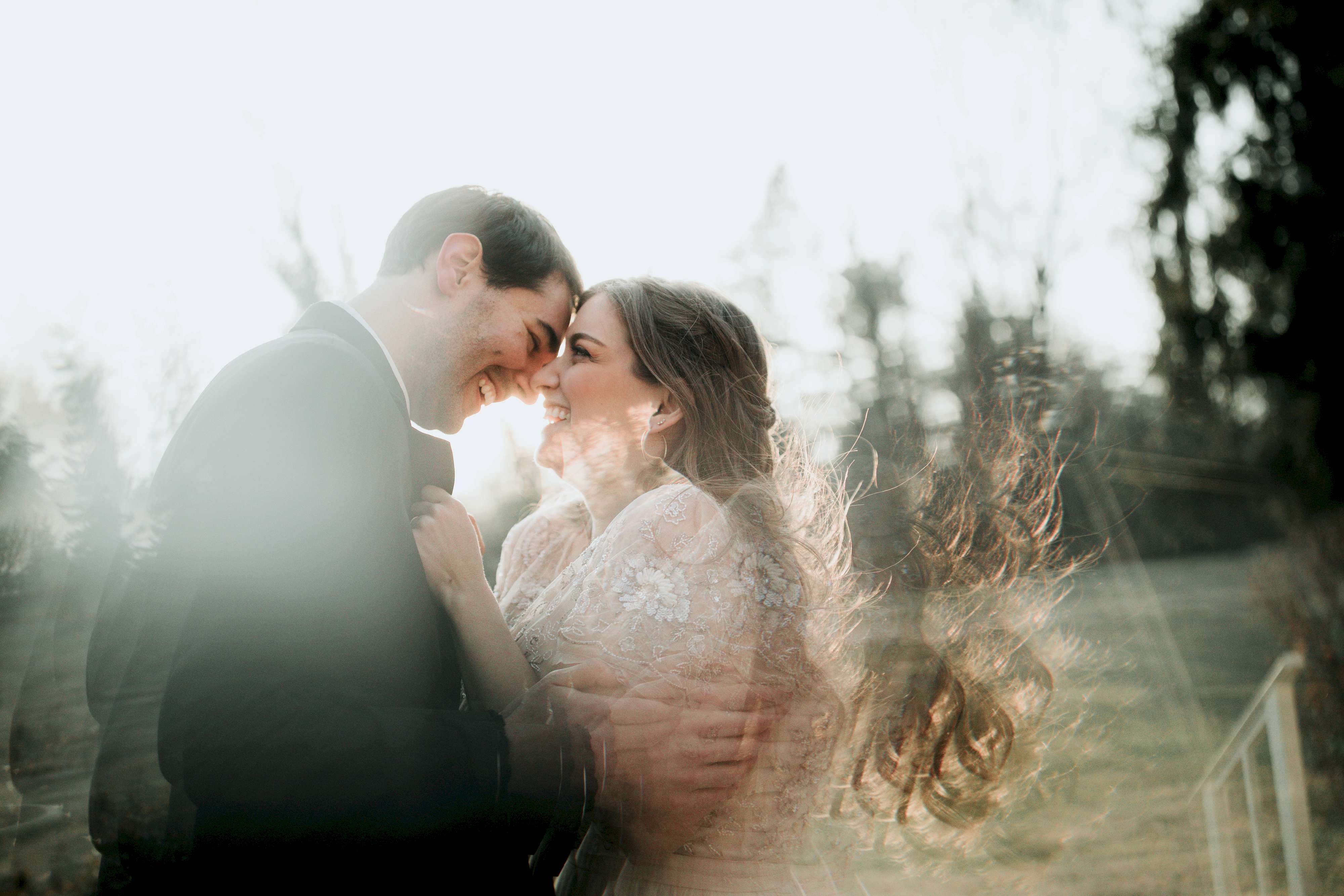 A wedding couple smile in the hazy sun.