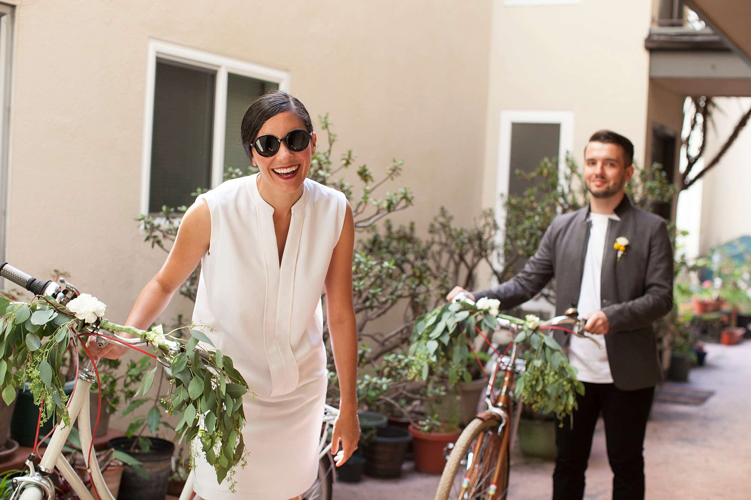 A couple walk with bicycles.