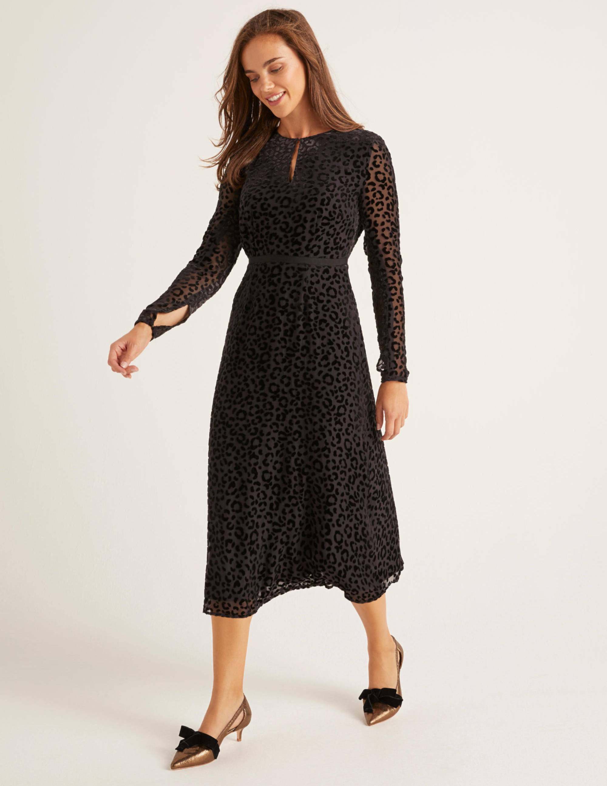 A model wears a dress described as being Crafted from silky viscose and covered in velvety leopard print, this on-trend midi dress is a statement staple. 
