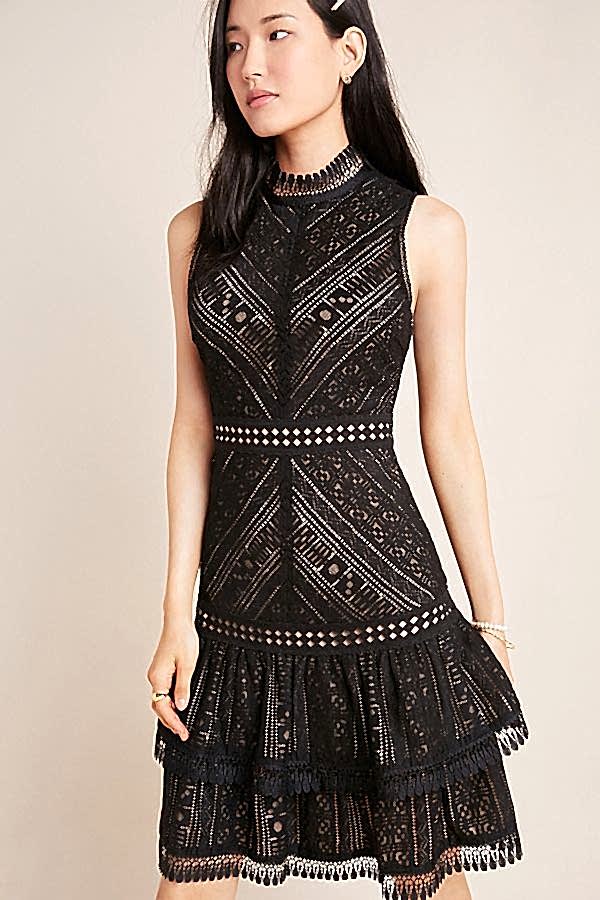 A model wears a Lace embroidery lends a refined, feminine aesthetic to this easy-to-style mini dress.