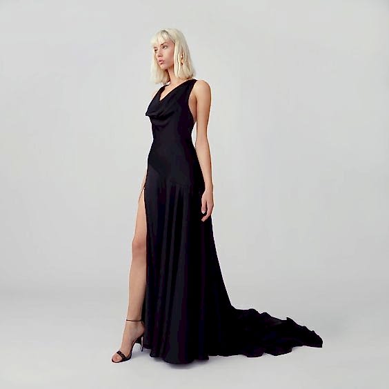 A woman wears an elegant full length black gown. Black wedding dresses.