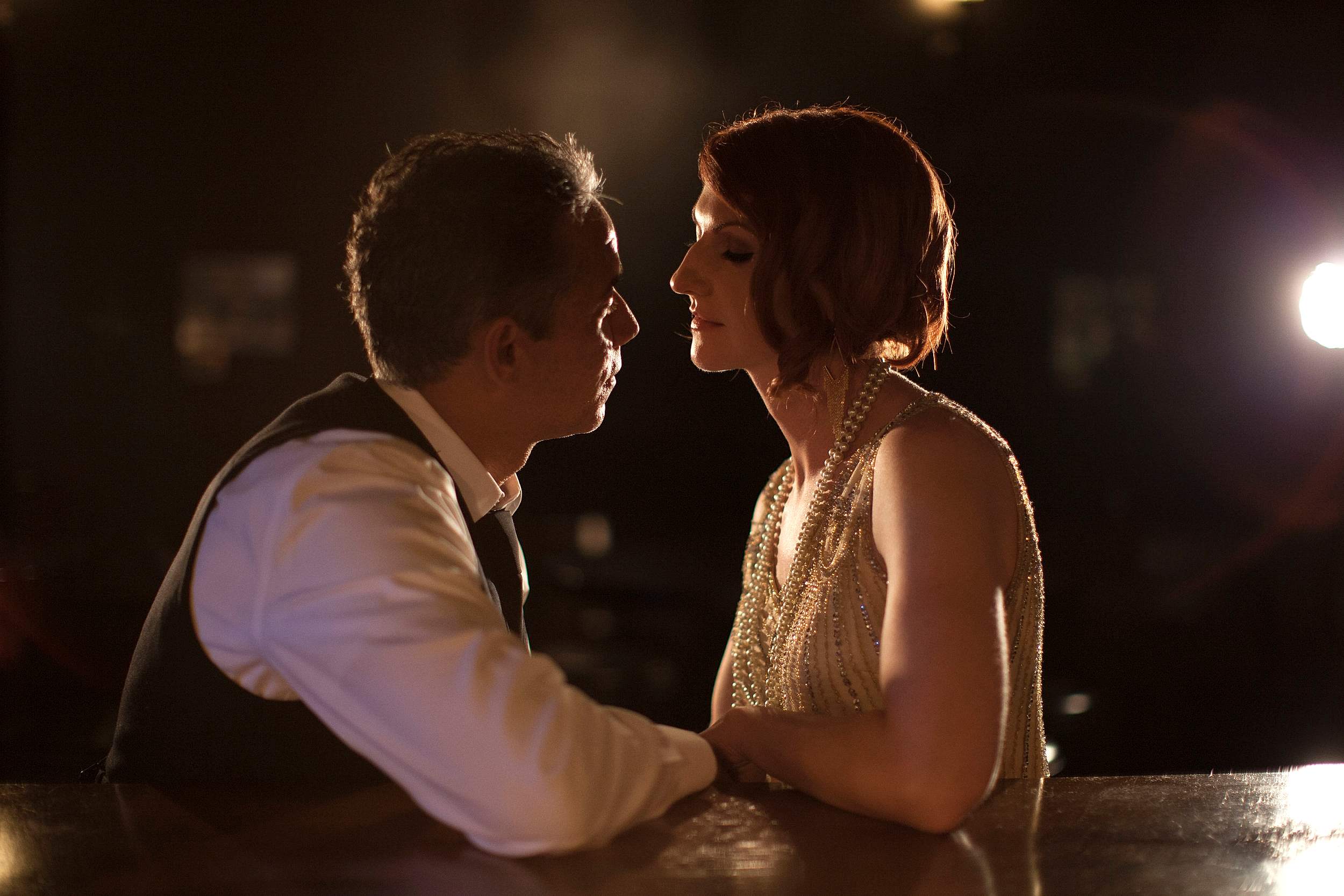 A wedding couple sit quietly in the darkness.