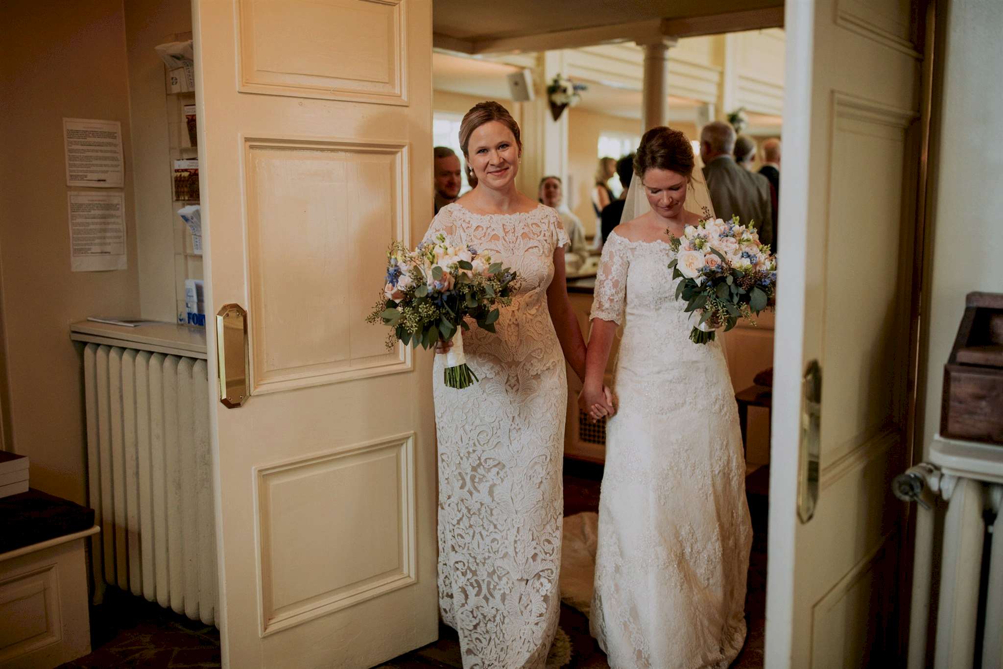Two women in wedding dresses make the recession from their ceremony.