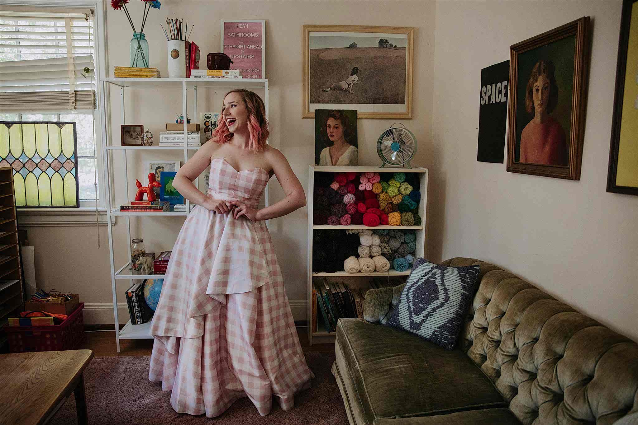 A woman poses in a room and smiles.