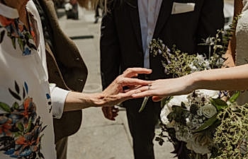 older woman looking at a bride's engagement ring