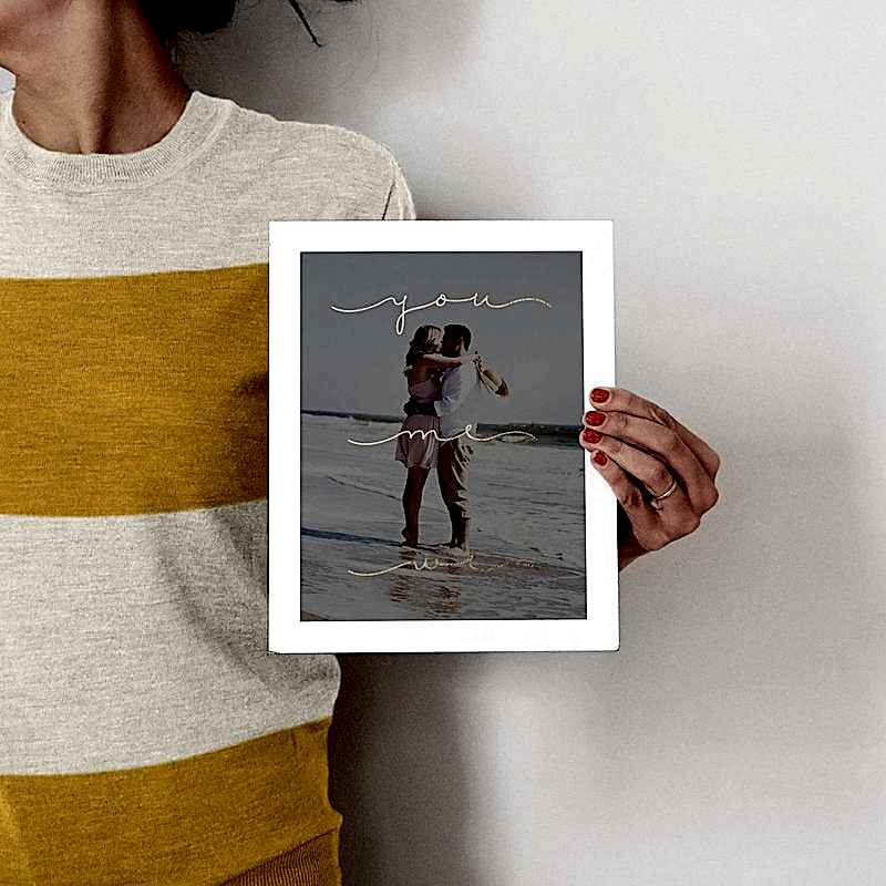 A person holds up a photo of other people.