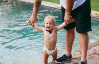 baby in a bow tie at a pool