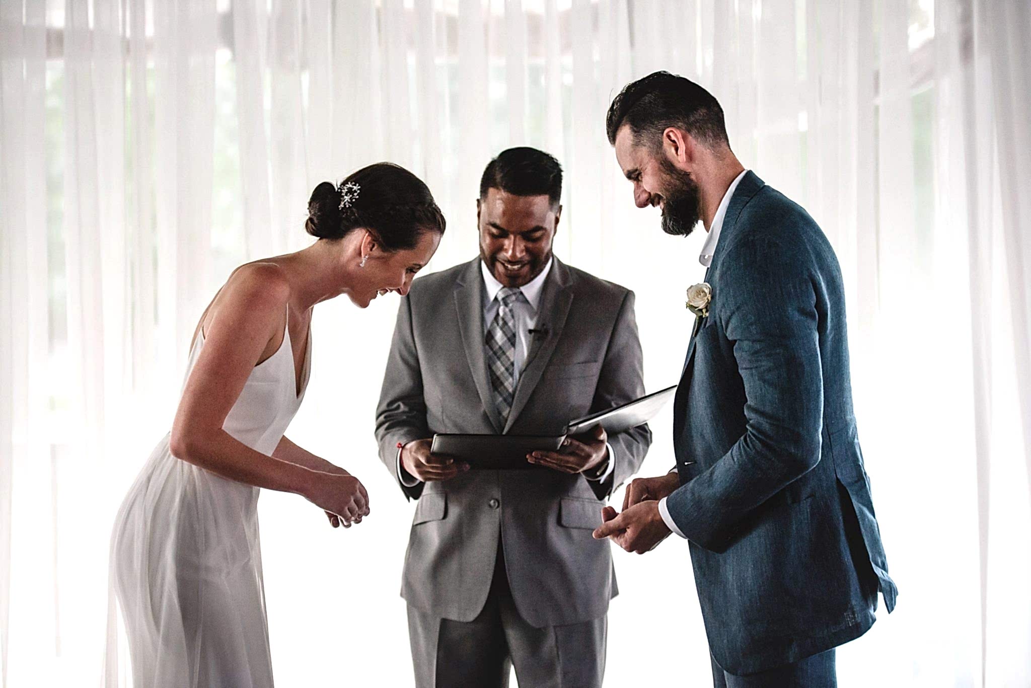 A wedding couple laugh during their ceremony.