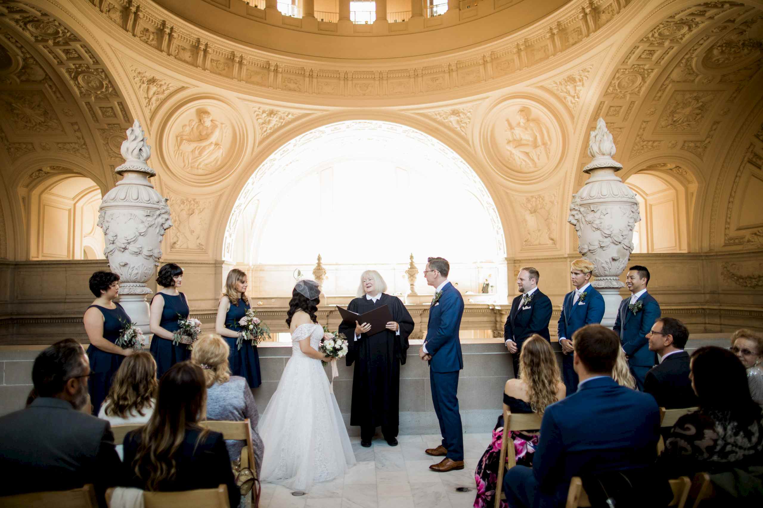 A wedding couple have their ceremony on a balcony in city hall.
