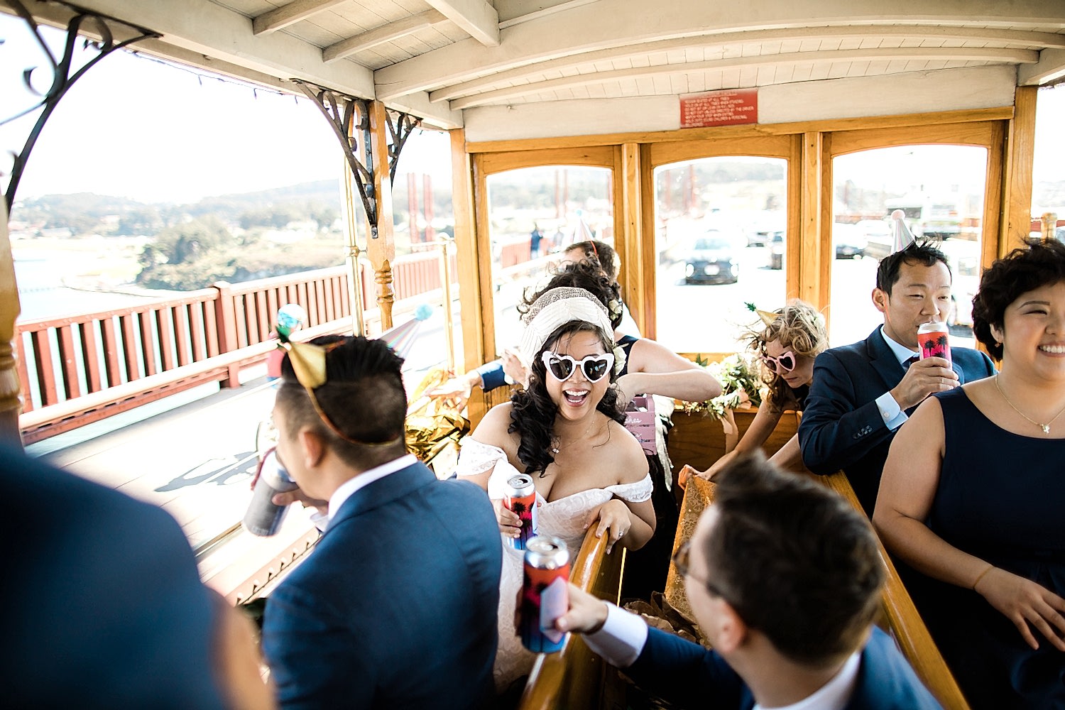 A wedding party ride a trolley over the Golden Gate Bridge.