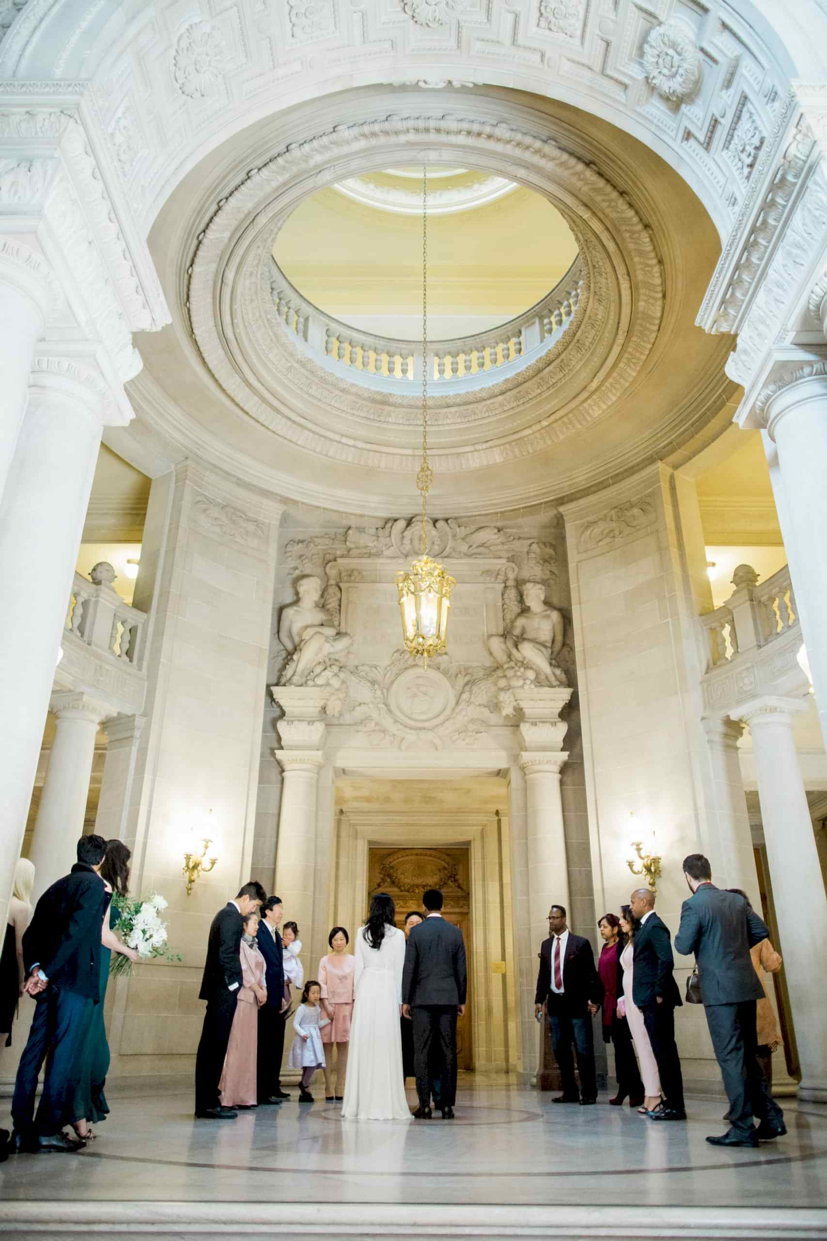 A wedding couple have their ceremony in the center of City Hall.