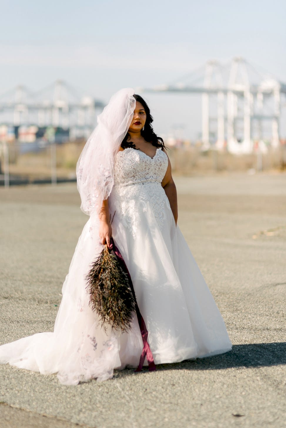 A women wears Maggie Sottero dress style 'Vanessa' with a veil and a bouquet.