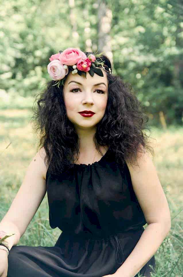 A woman wears a pink silk flower crown