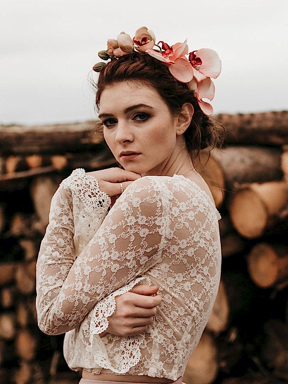 A woman wearing a flower crown with peach colored flowers.