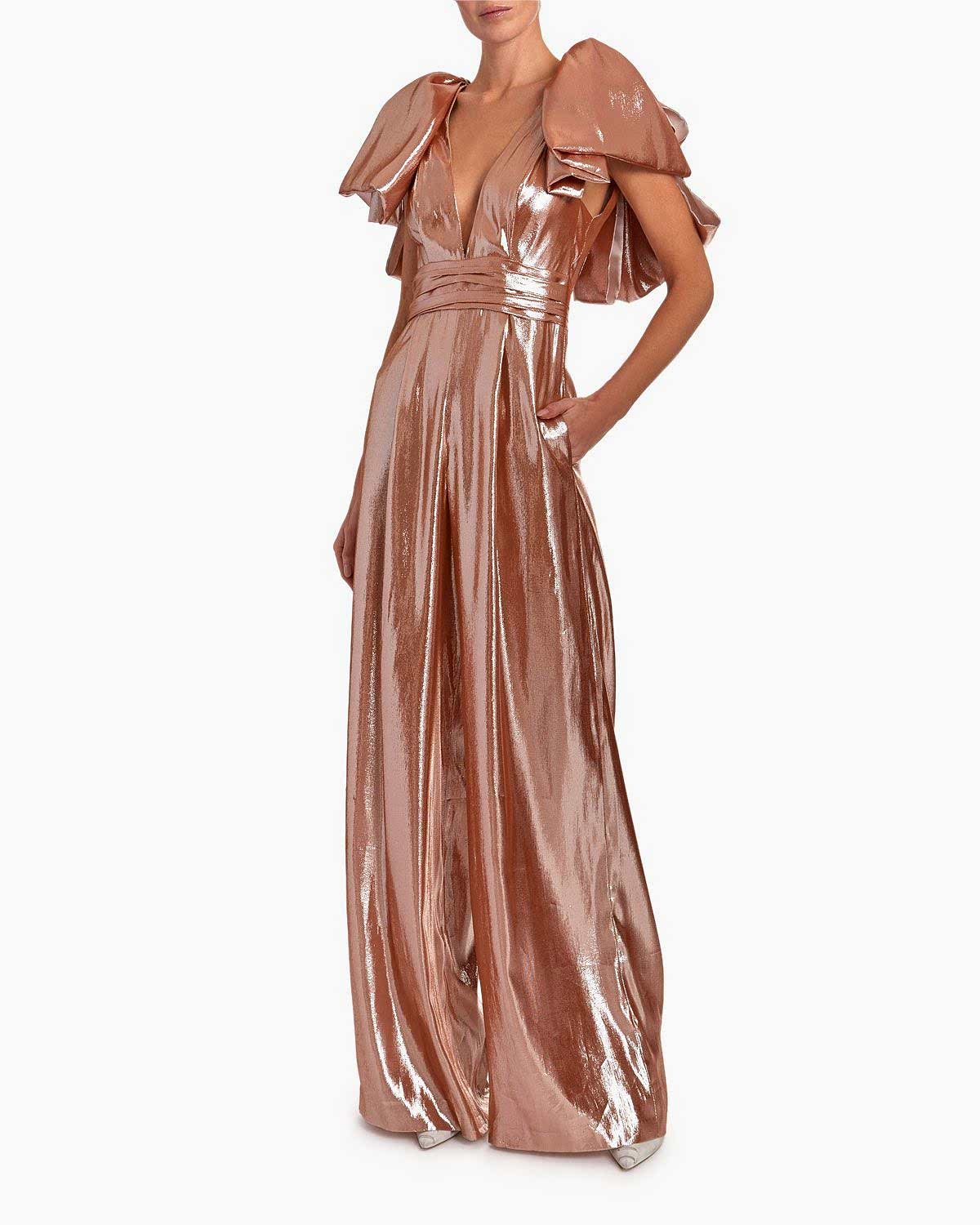 A woman wears a gold color lamme wedding jumpsuit.