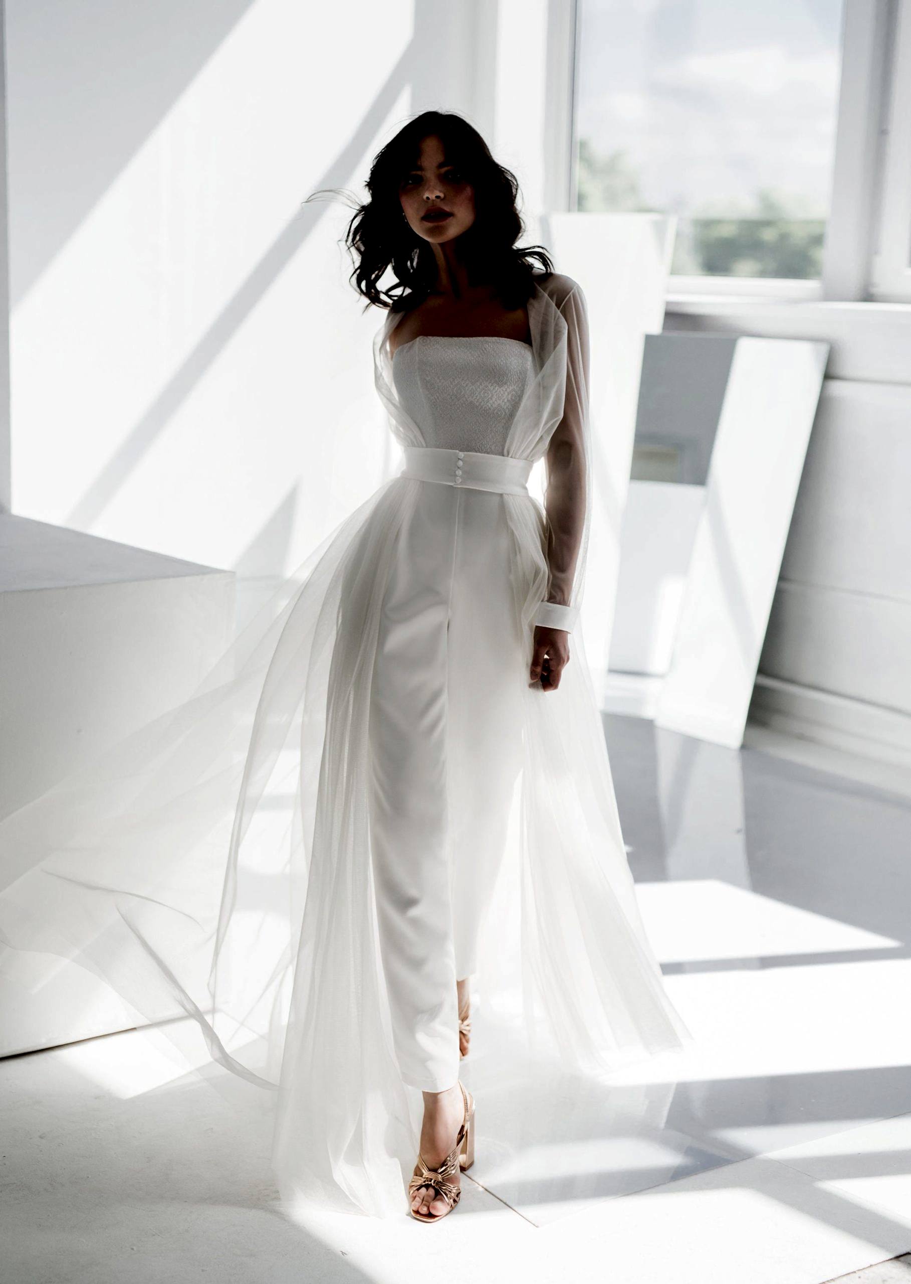 A woman wears a flowy wedding jumpsuit.