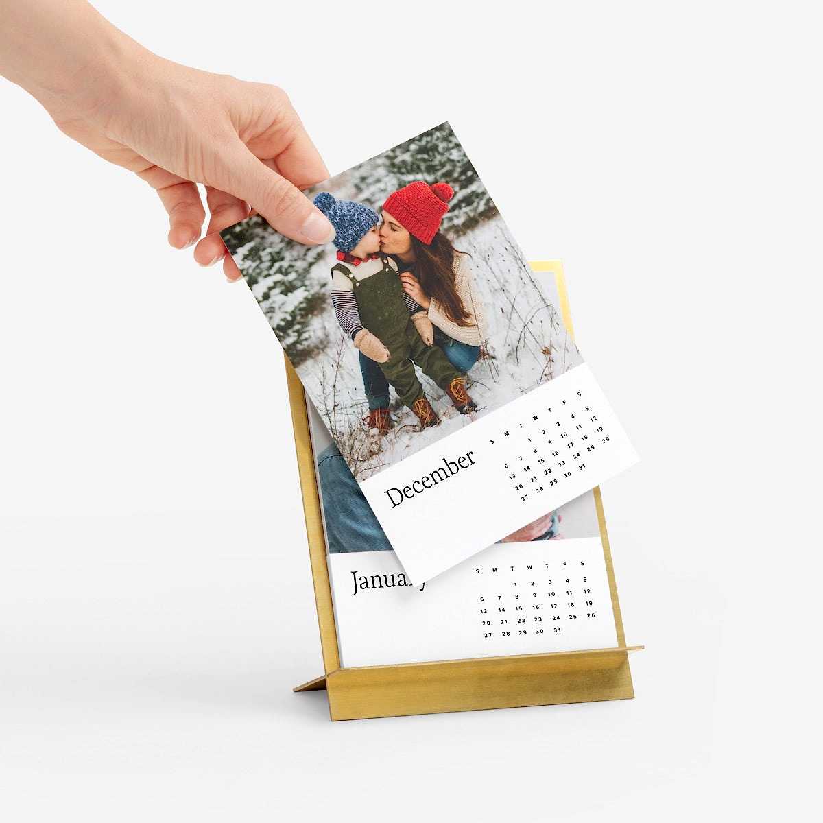 hand changing a calendar date card on a brass easel