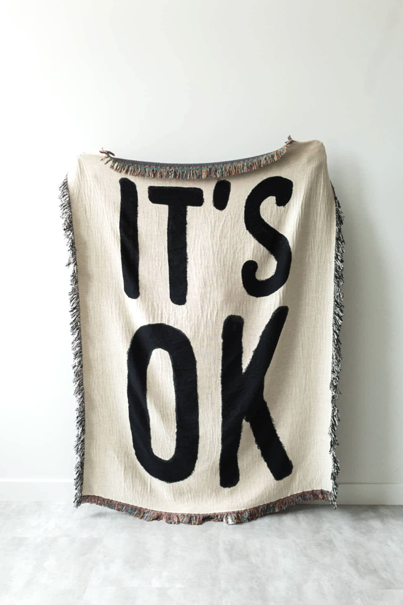 white and black blanket that says "it's ok"