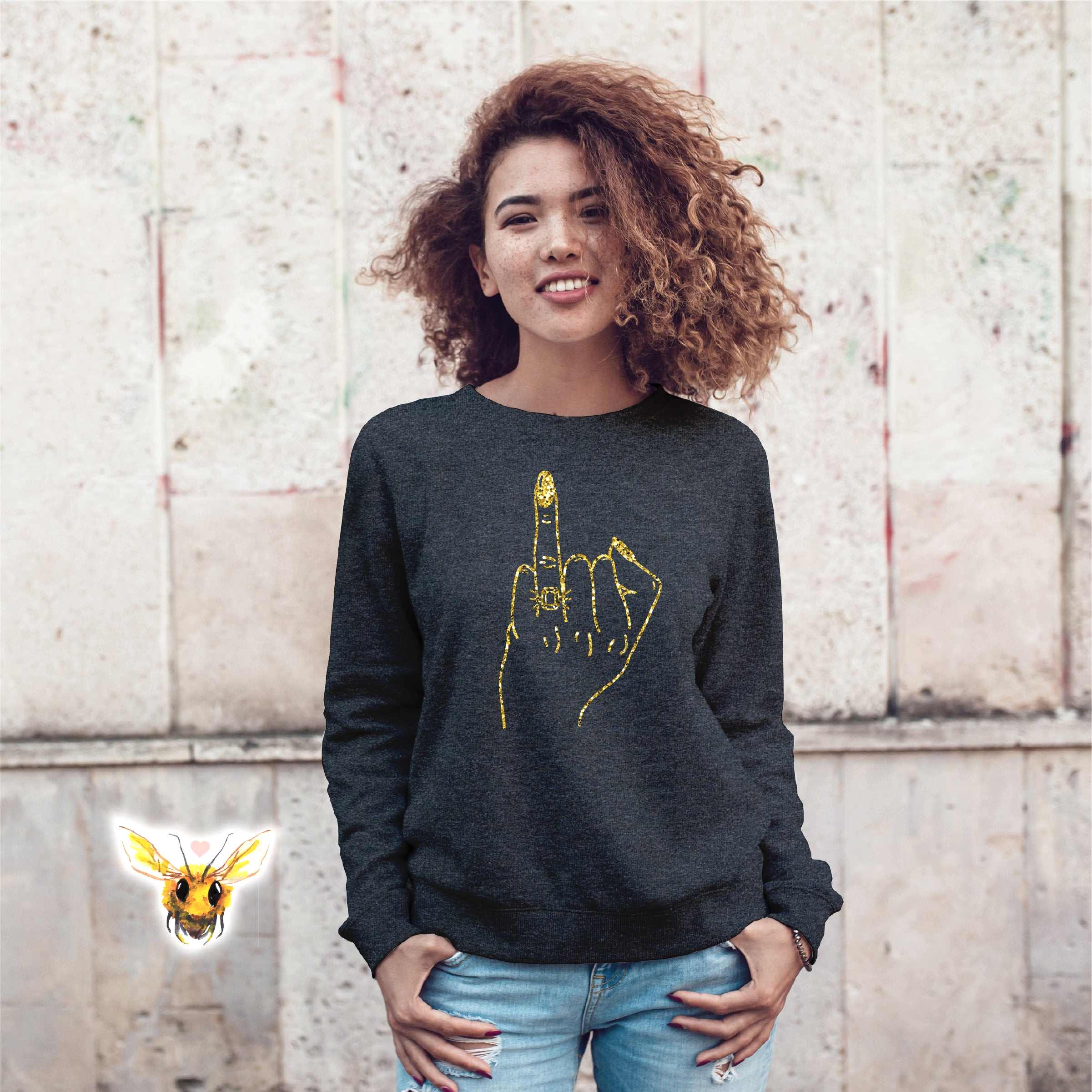 woman smiling wearing a sweatshirt with the ring finger up