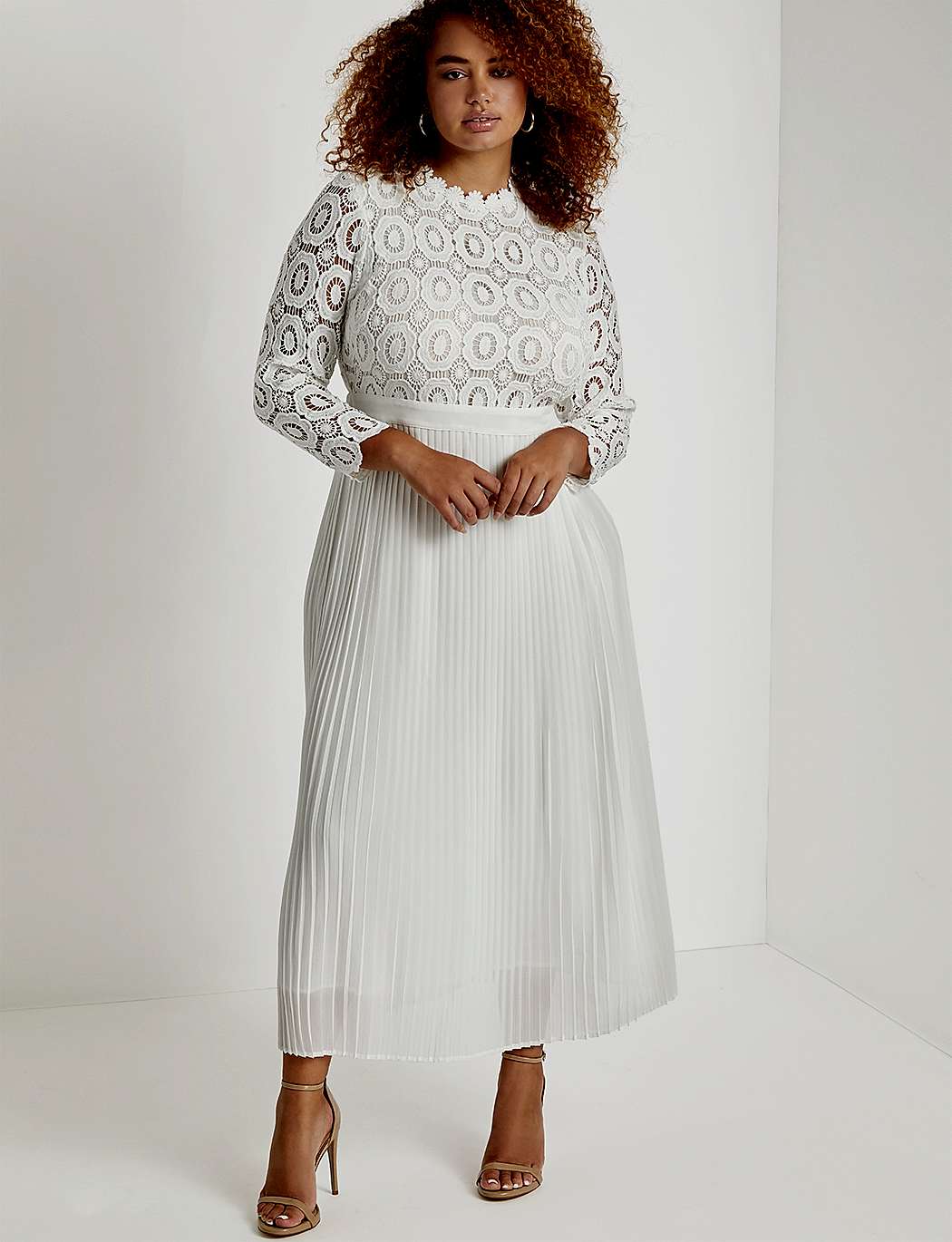 Woman with dark hair in white lace and pleated dress