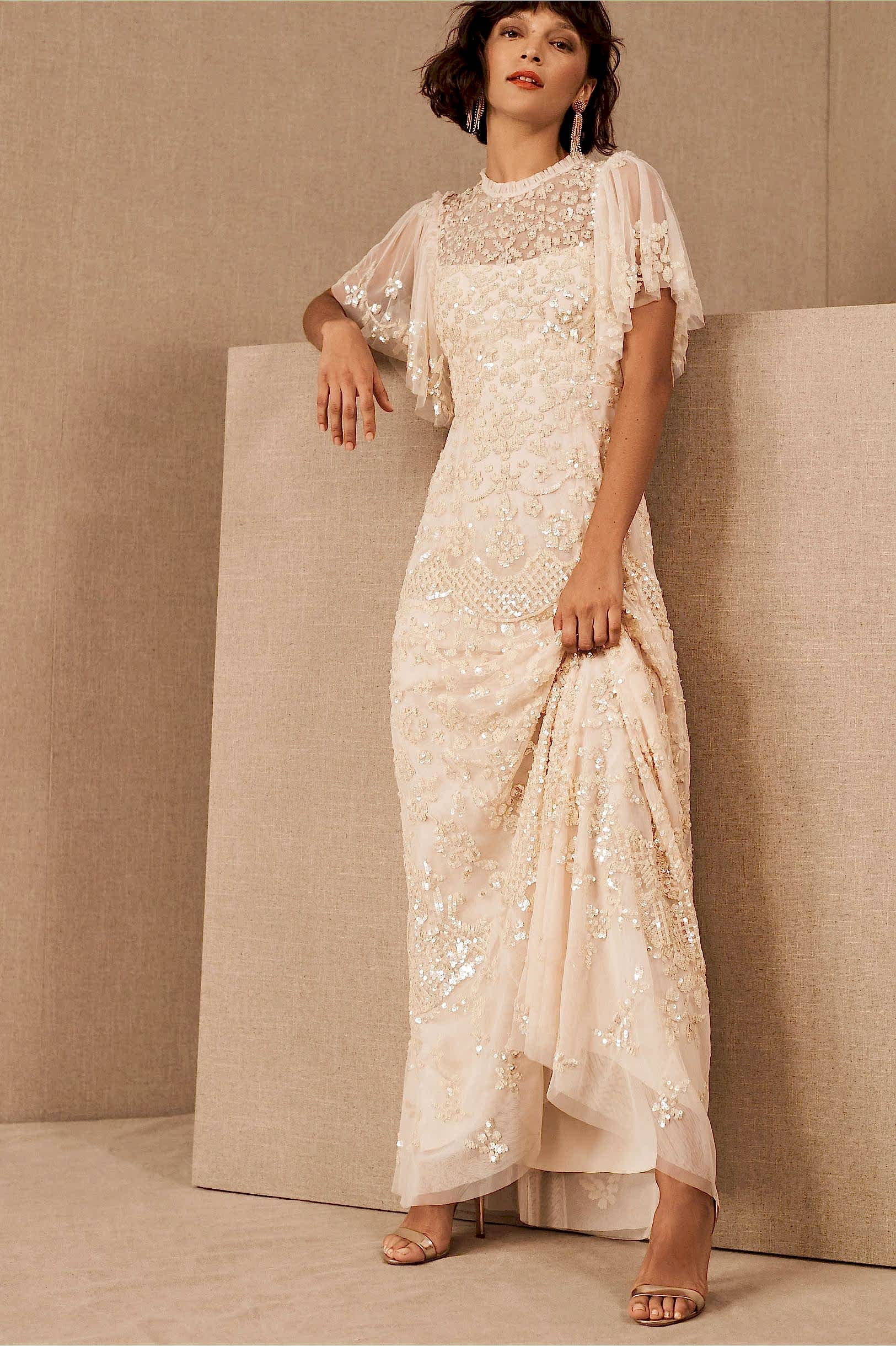Woman with dark hair in cream and sequin lace wedding dress