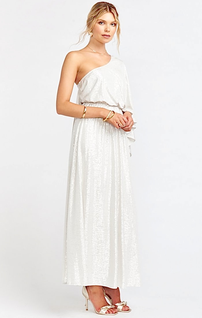 Woman with blonde hair in white and silver shimmery one sholder gown