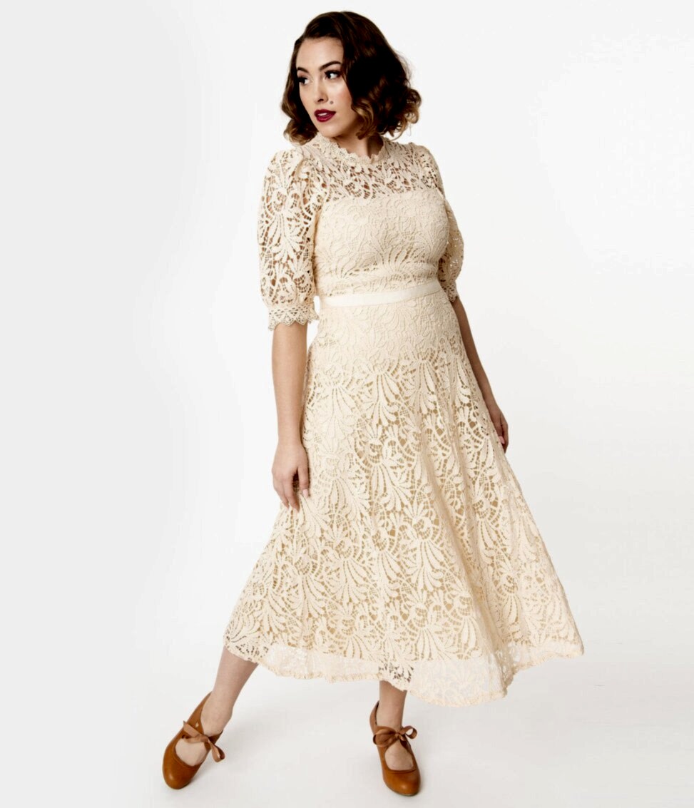 Woman with dark hair in cream colored lace wedding dress in vintage style