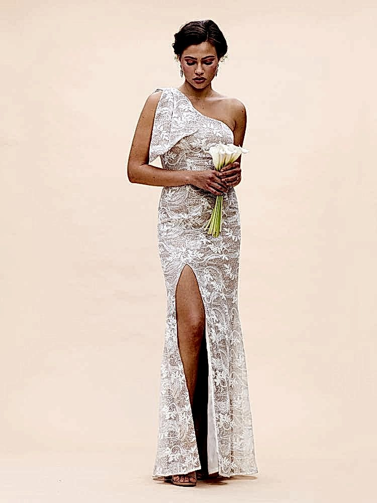 woman in lace one shoulder slit dress holding calalily flowers