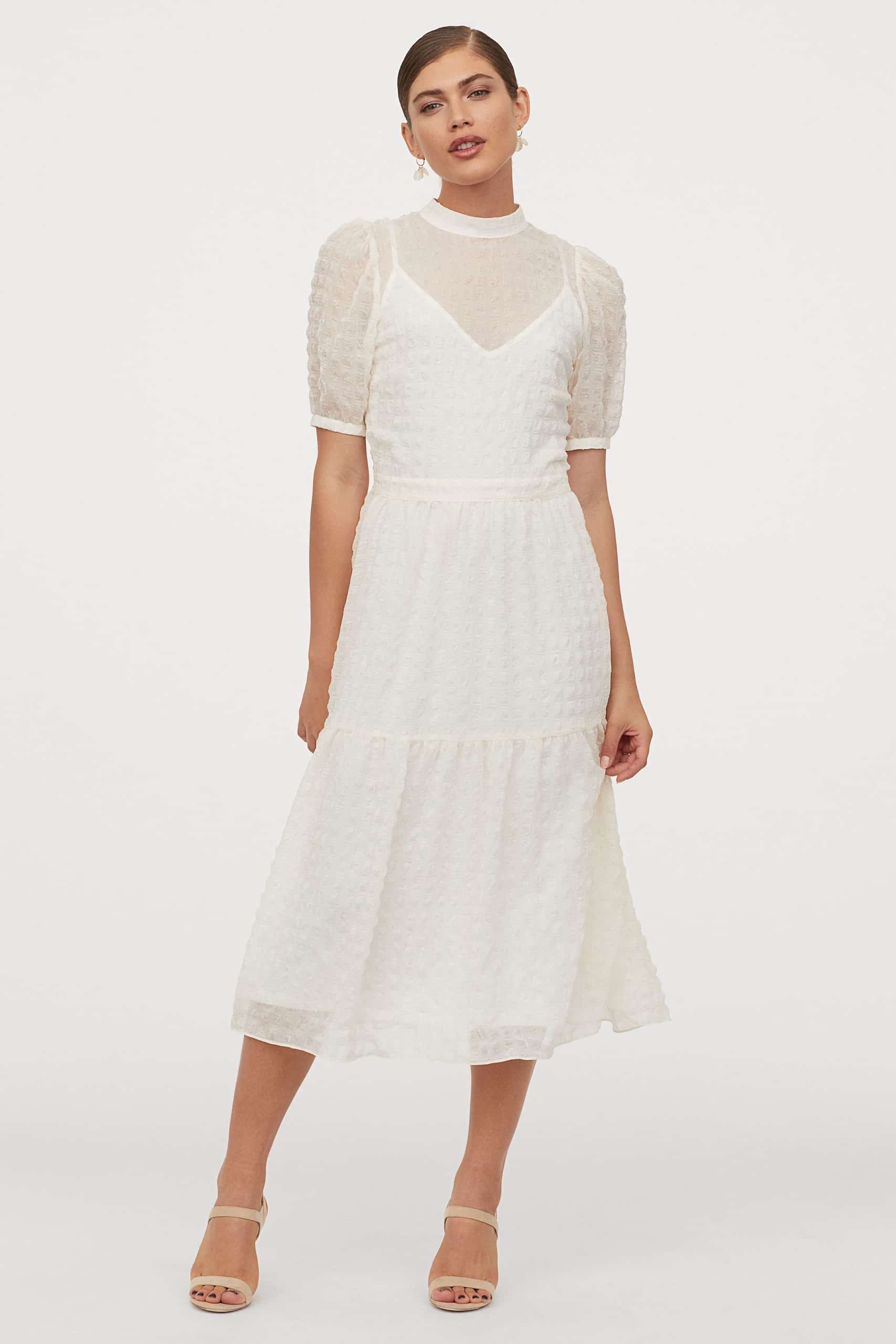 Woman with dark hair in white lace dress