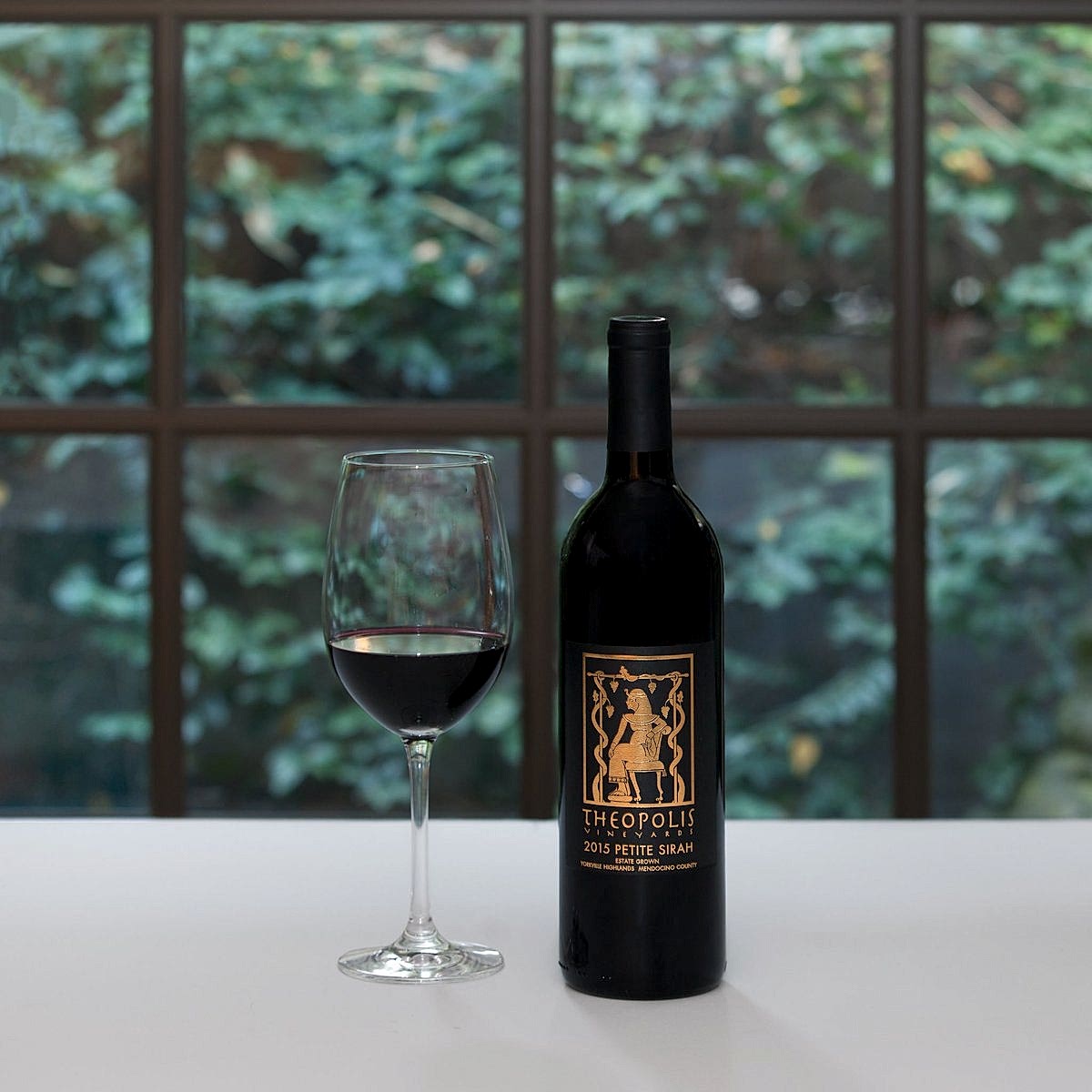 a glass and bottle of wine on a white tablecloth