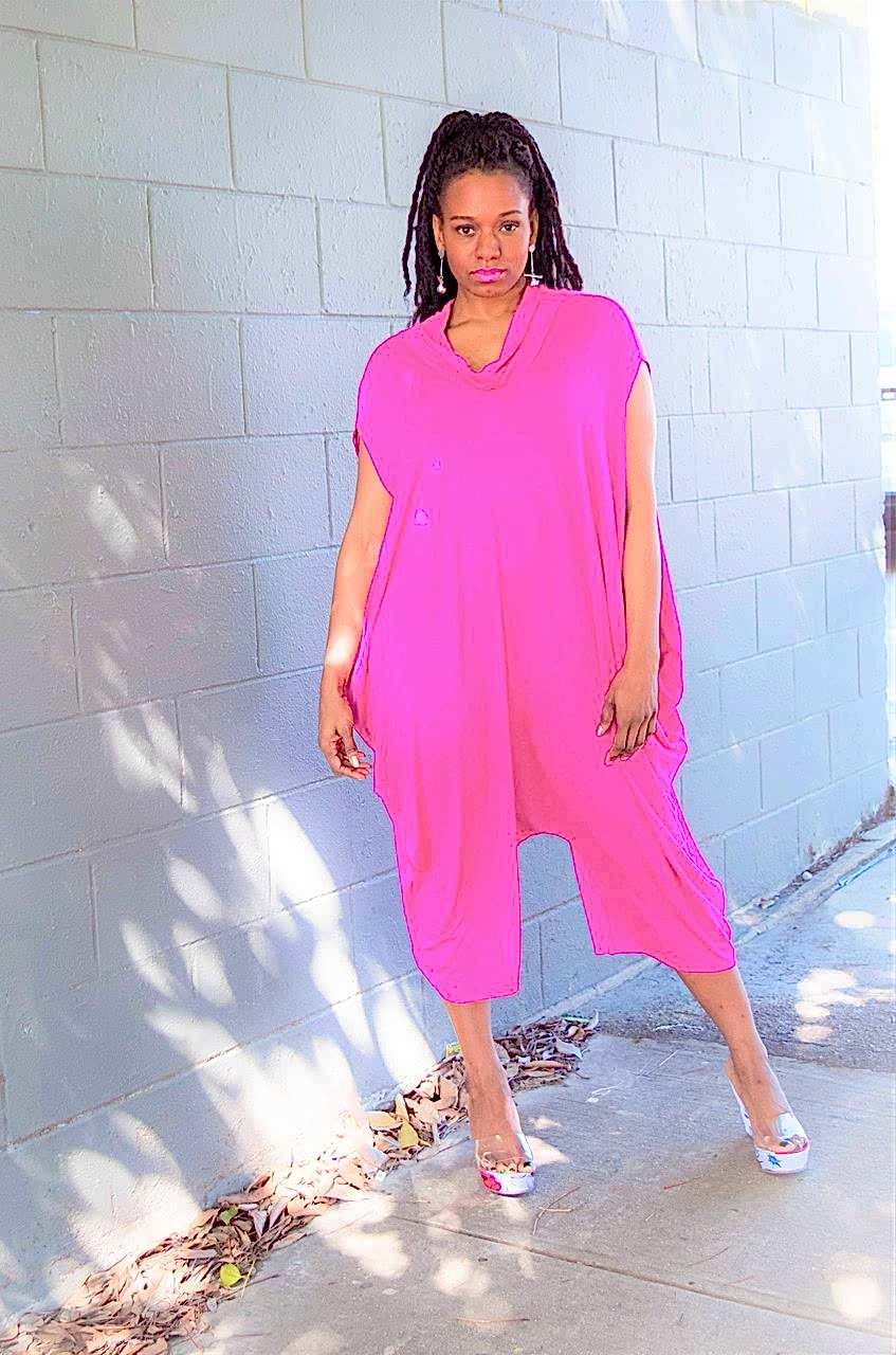 black womxn wearing a bright pink jumpsuit