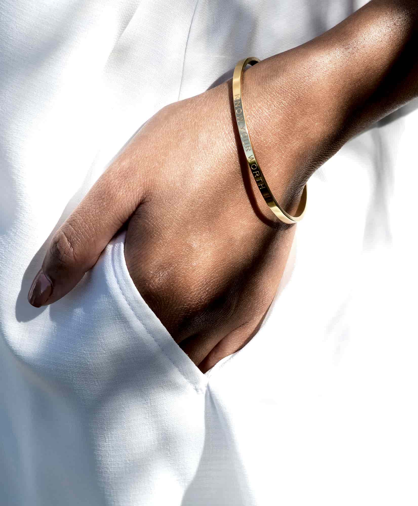 gold bracelet with a hand in pocket
