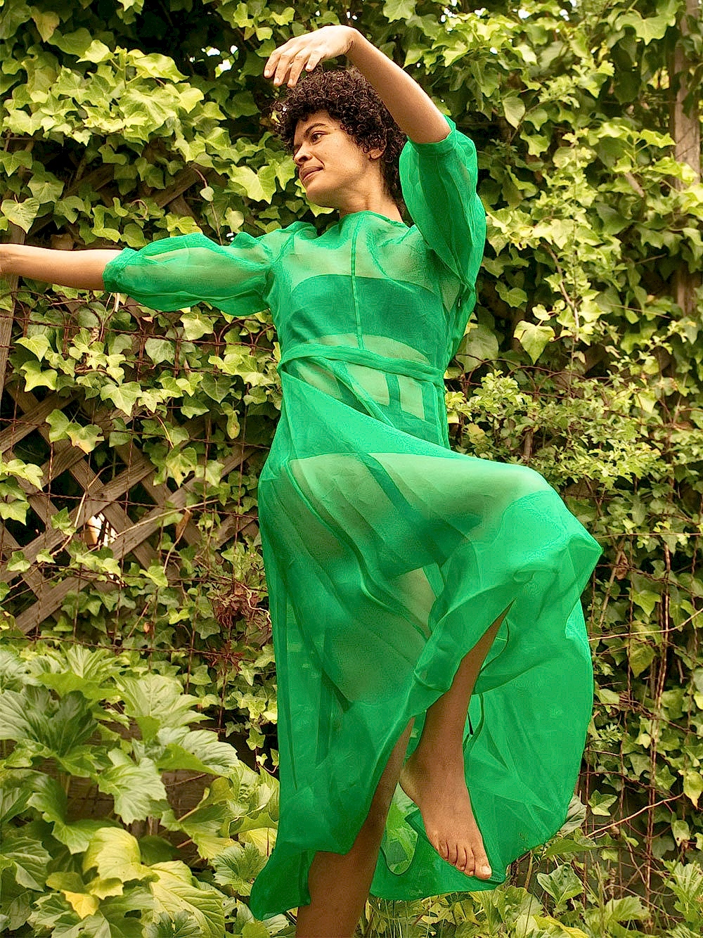 black womxn dancing wearing a kelly green dress