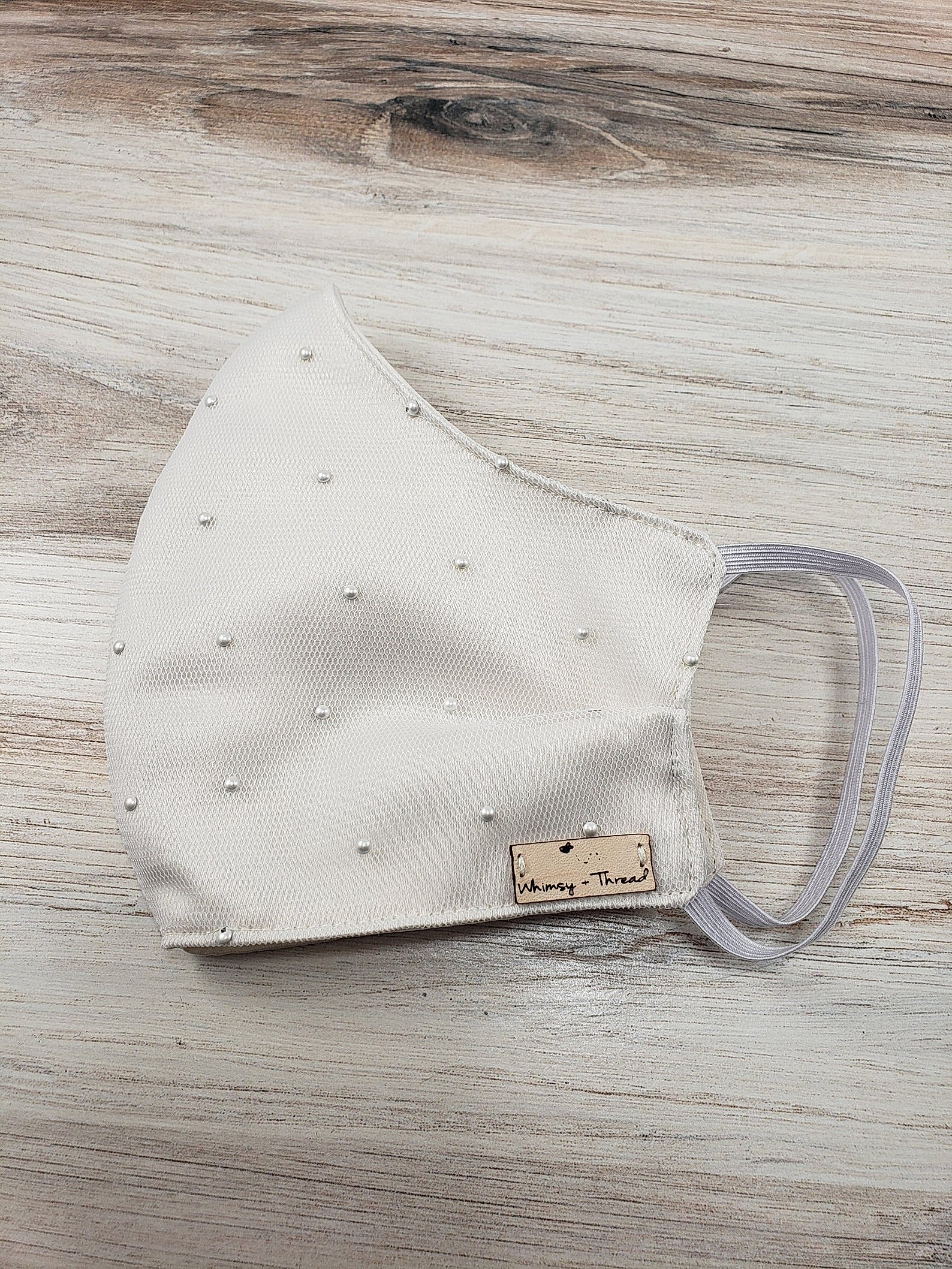 folded face mask adorned with pearls