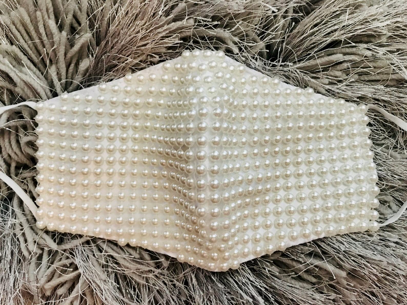 white pearl mask on top of fluffy background
