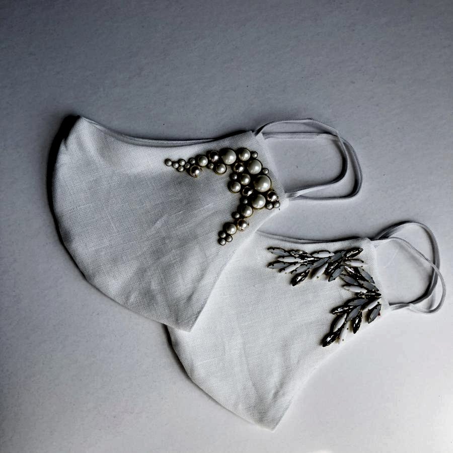 two folded white embellished wedding face masks