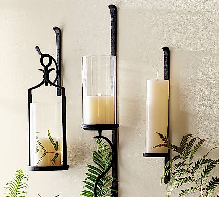 cast iron black wall hangings holding white pillar candles