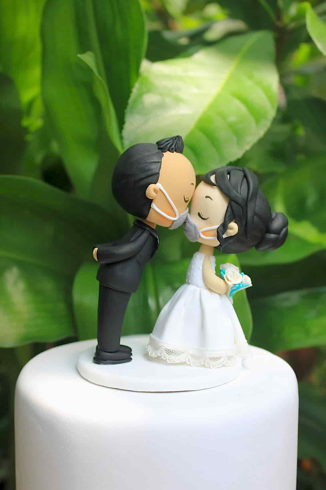 2020 fall wedding ideas include cake toppers with masked couples kissing